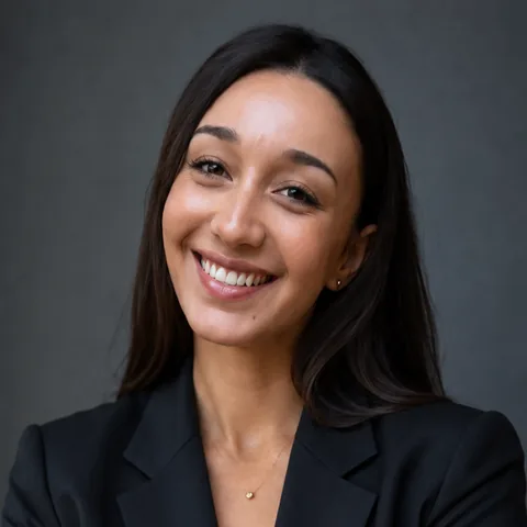 Salma, smiling, in a black blazer